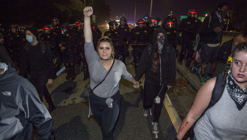 epa05626347 A demonstrator being pushed off the freeway by the California Highway Patrol after fellow demonstrators blocked traffic on HWY 580 freeway during marching through the streets in protest against President-elect Donald Trump in Oakland, California, USA 10 November 2016. Hundreds filled the streets of downtown Oakland for the second night to march against the Trump presidency. EPA/PETER DASILVA